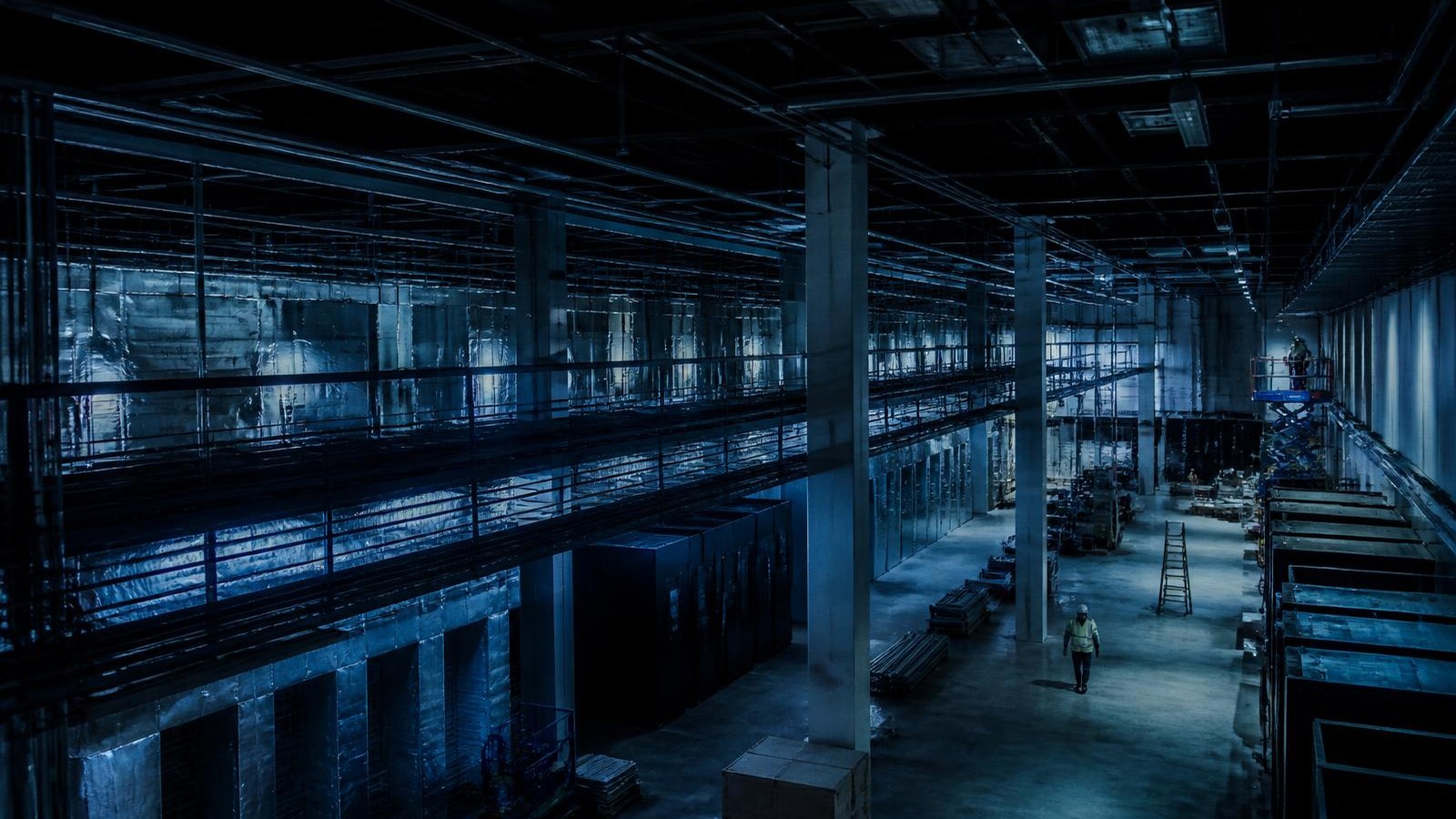 Large facility under construction with crews working at distance